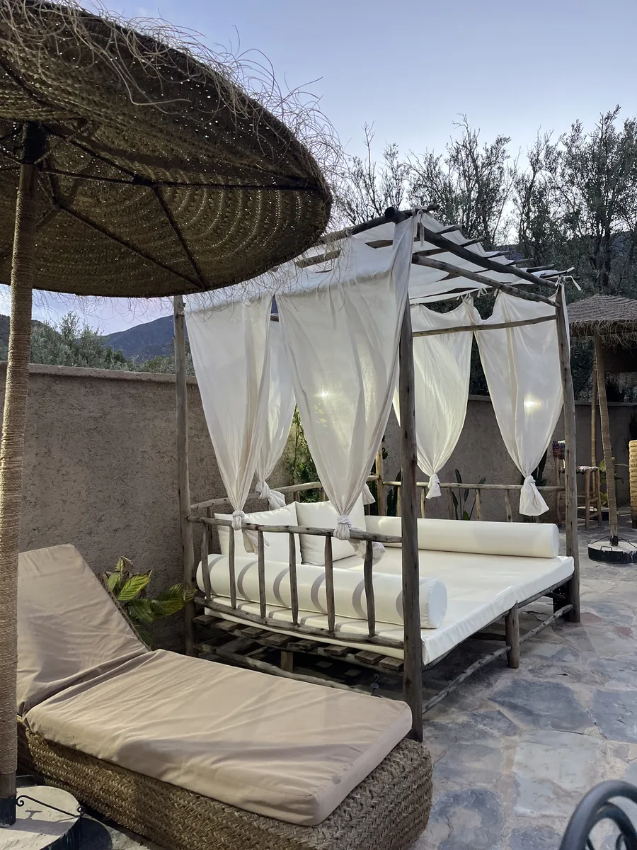 Espace lounge extérieur avec daybed sous baldaquin — Wild Valley Ouirgane, Haut Atlas Maroc